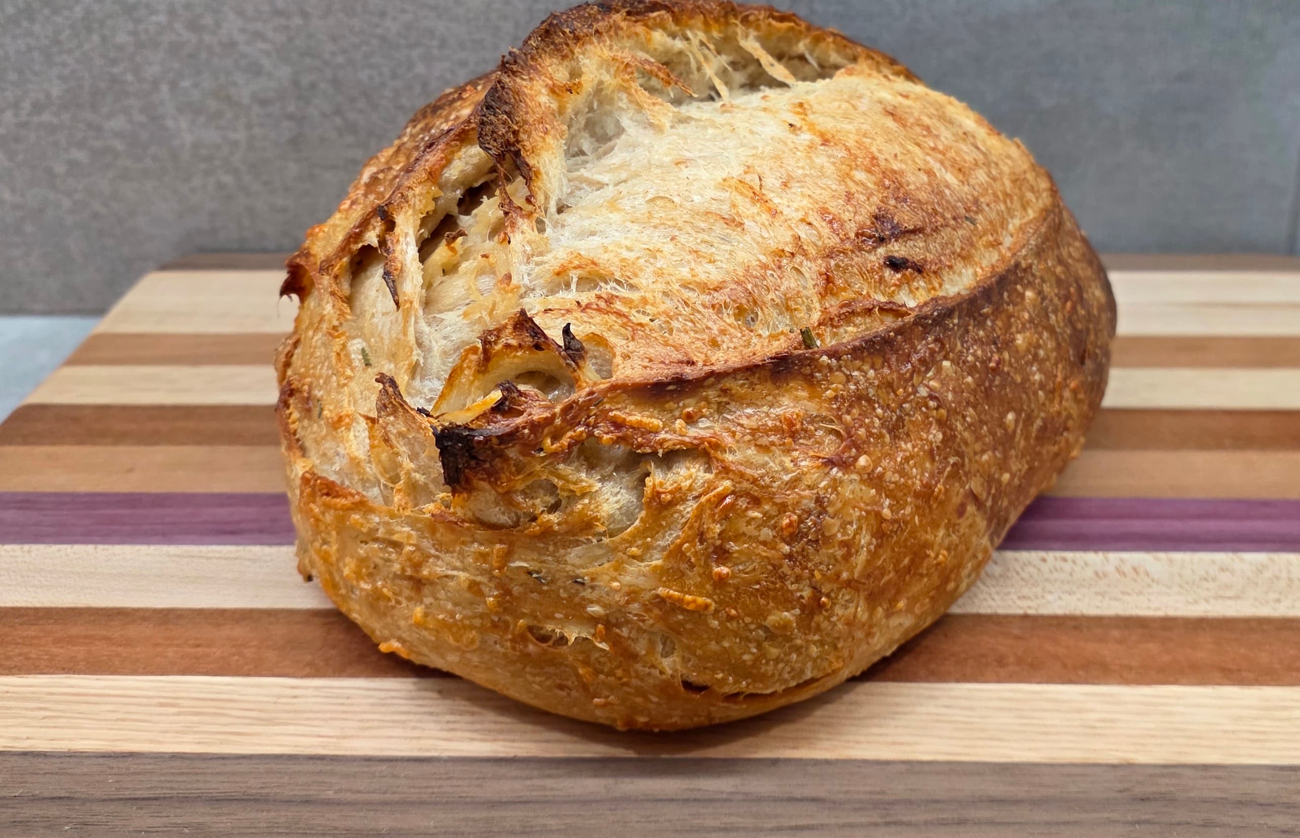 Crusted Love sourdough loaf with blistered crust on a wood board